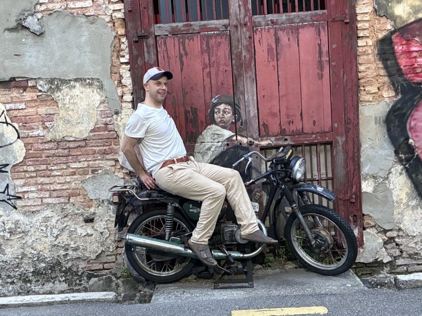 alberto sitzt auf einem motorrad vor einer roten holztür, coaching, resilienz